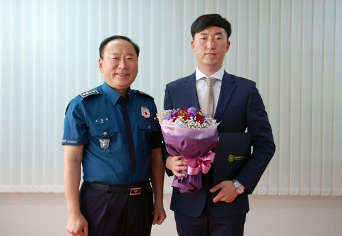 손호진씨(오른쪽)가 7일 보령경찰서에서 표창을 받고 조법형 보령서장과 기념촬영을 하고 있다.  보령경찰서 제공